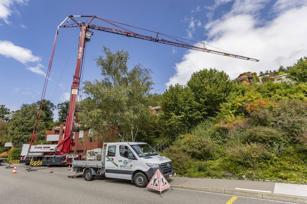 Göldi AG Auto mit Kranen in einer Nachbarschaft