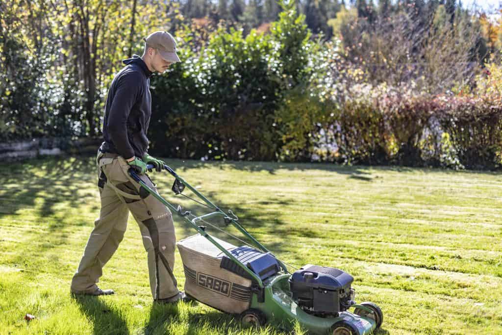 Ein Göldi Gärtner an in einem Privatgarten am Mähen