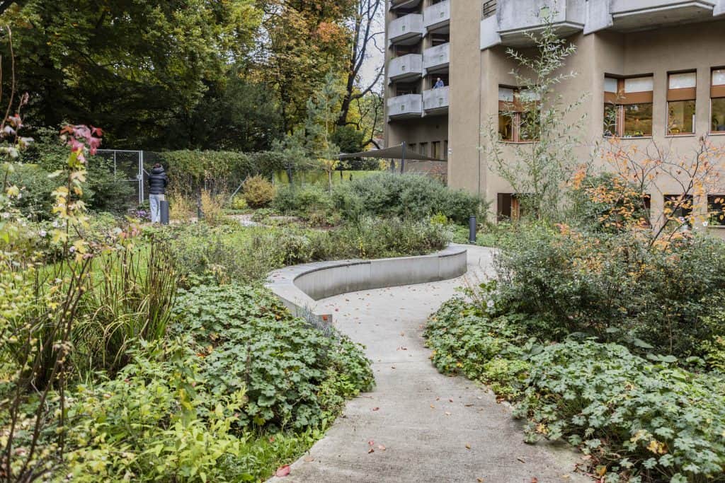 Einladende Gartenanlage, mit Sitzbank und Blumen